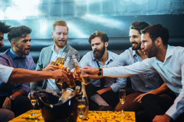 Group of young men toasting with beer